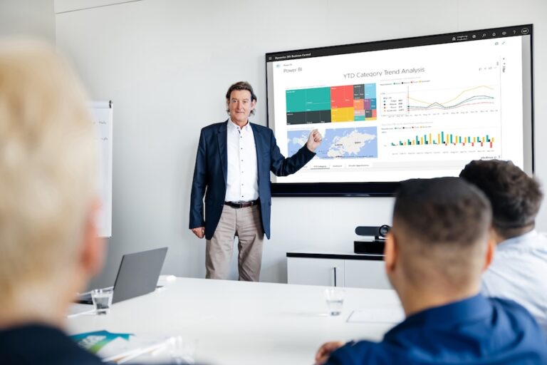 Mann präsentiert Power BI Lösung am Bildschirm.